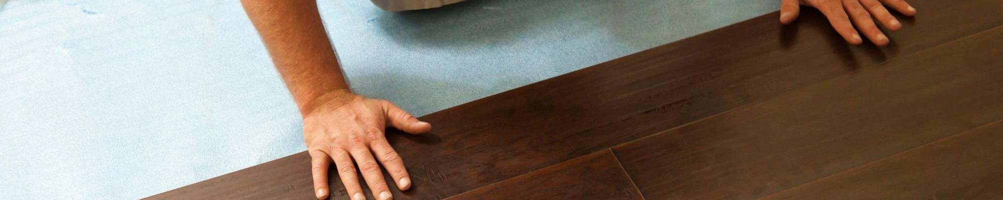 man laying down hardwood flooring - House of Carpet Inc in VA